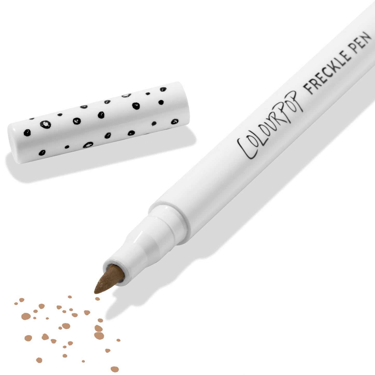ColourPop Freckle Pen in Soft Brown uncapped, felt-tip applying scattered soft brown freckle dots, with polka-dot white cap beside it on a clean white background; long-wearing, buildable faux freckles makeup.