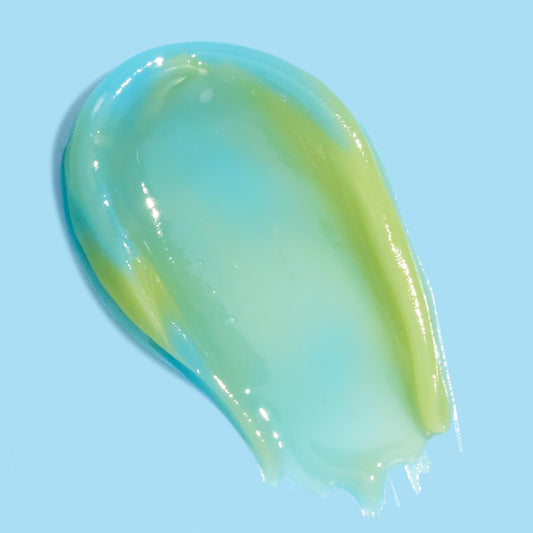 The Chosen One ColourPop Lip Mask swatch, a glossy gel smear transitioning from aqua blue to lime green, revealing a smooth, cushiony texture on a pale blue background that highlights hydration and high shine.